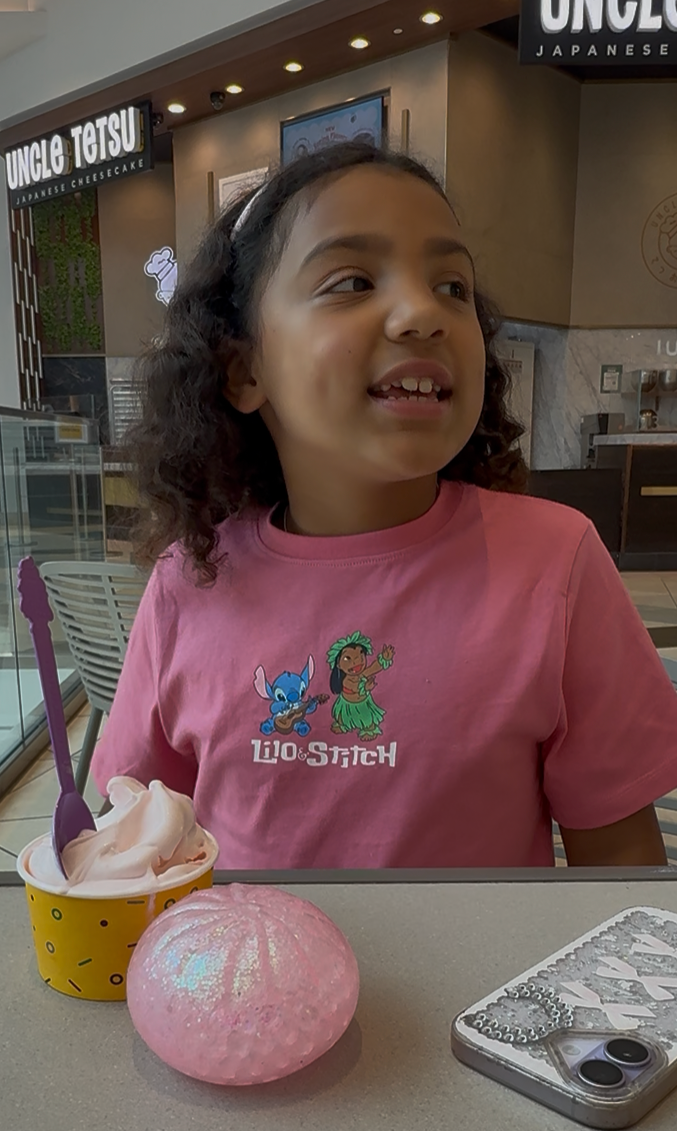 Chanel, the owner, smiling with a pink squishy and ice cream